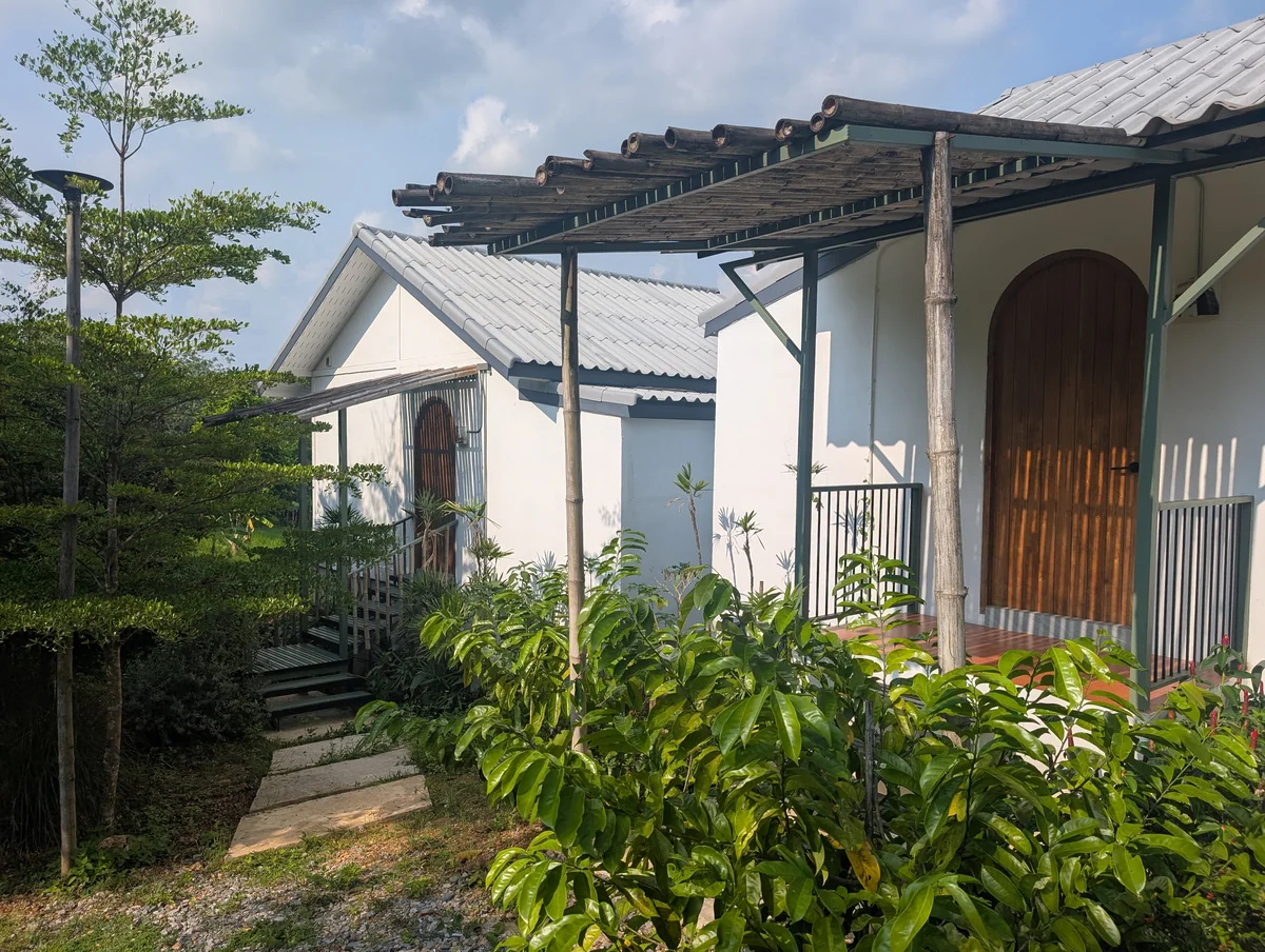 Both cottage entrances with wooden doors, garden planting and a shared approach.